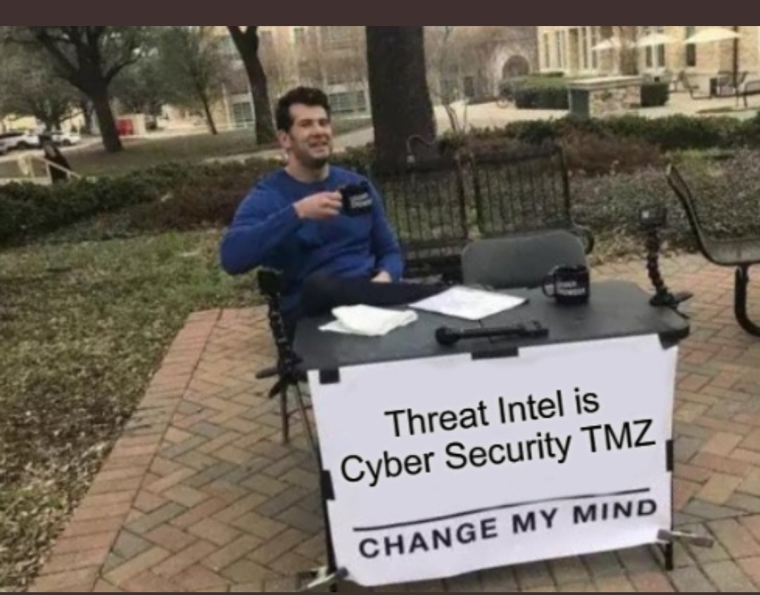 A man sits behind a desk with a sign reading “Threat Intel is Cyber Security TMZ. Change my mind.” (source: VX Underground)