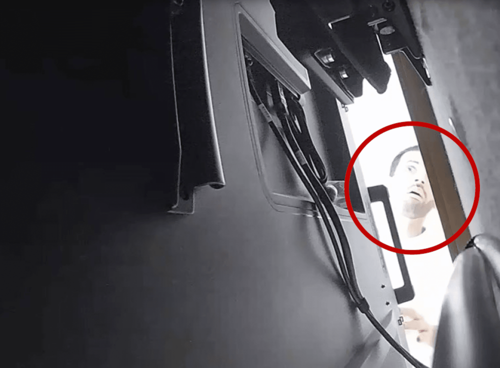 Alfozan allegedly checking for the secret recording device installed behind an OpenAI meeting room TV (Source: DOJ)
